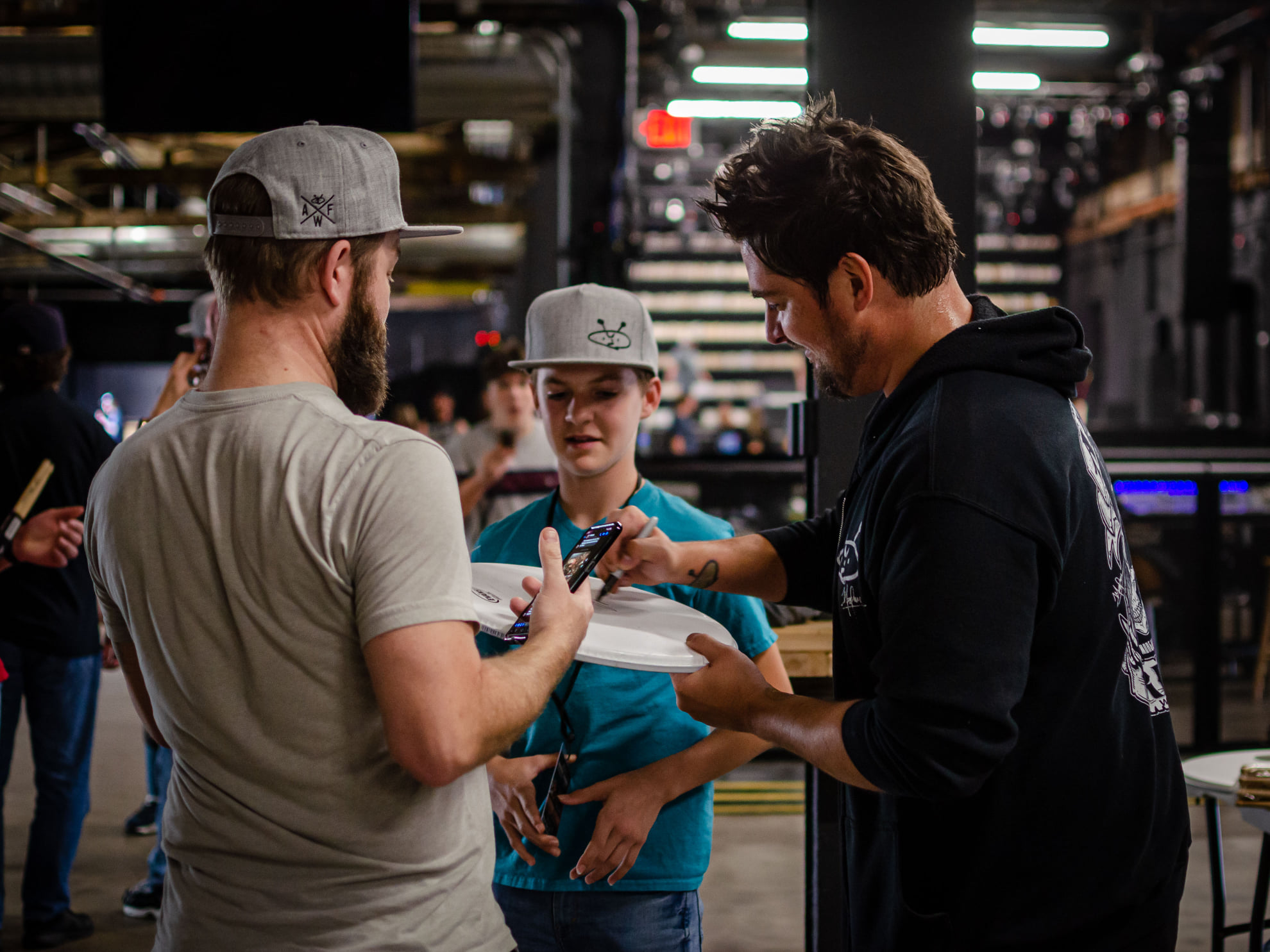 Musicians signing items for fans at in-person event